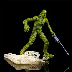 Creature from the Black Lagoon figure posed dynamically with a spear and a net on a reflective black surface.