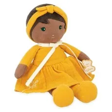 Kaloo fabric doll with brown skin and dark hair, wearing a mustard yellow dress, sitting down.