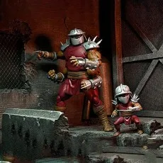 TMNT figures, large four-armed Shredder and baby clone, in a sewer setting.